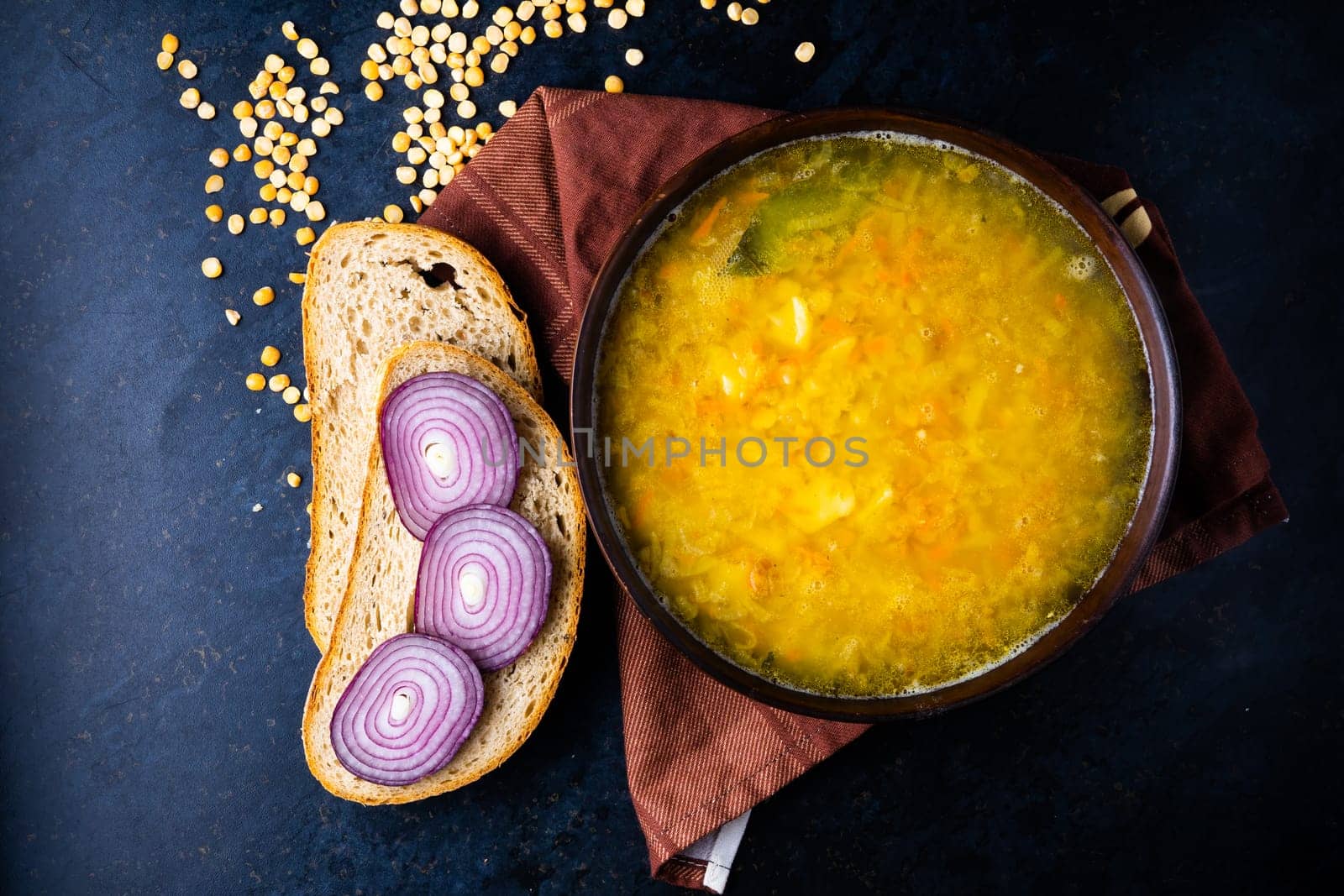 Homemade healthy vegetable soup with some bread and an onion