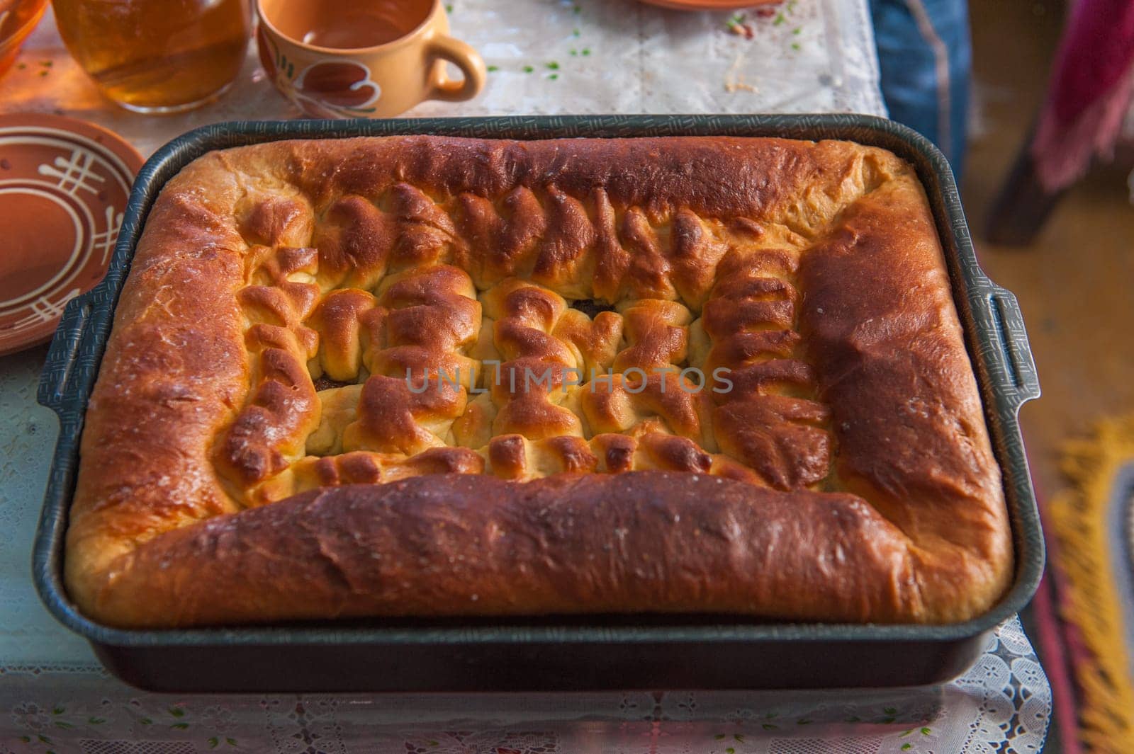 Closed pie with dough, minced meat and potato on wooden table