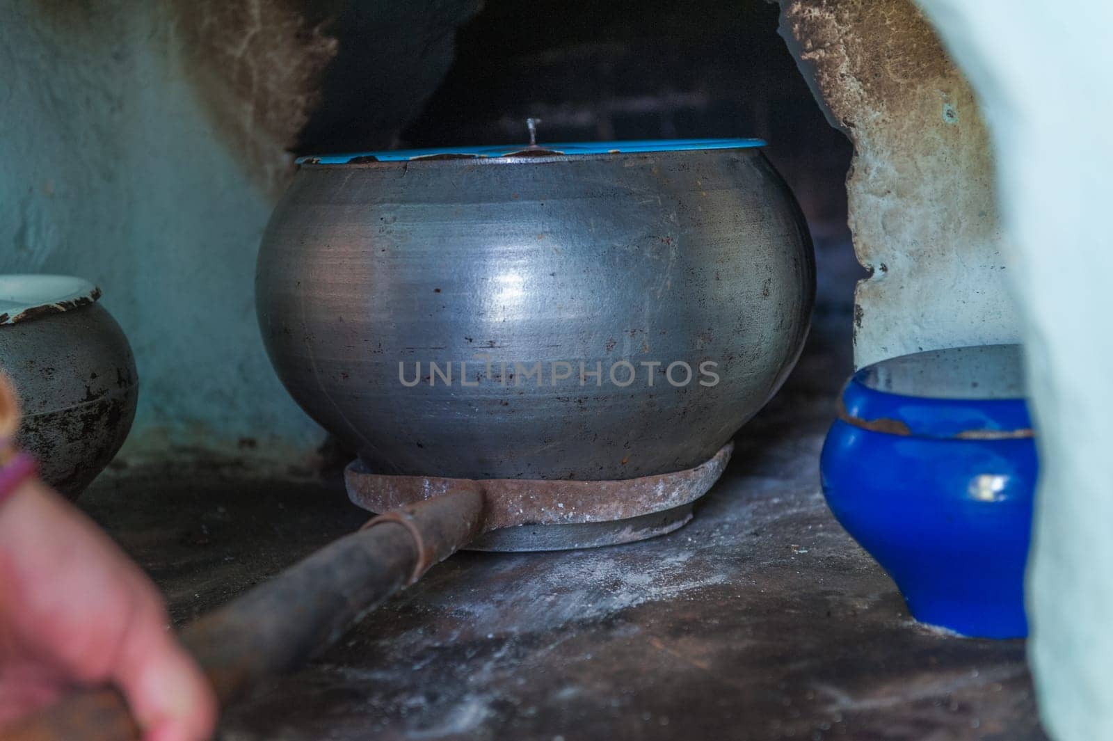Traditional cooking in iron cast cauldron in wooden fire stove