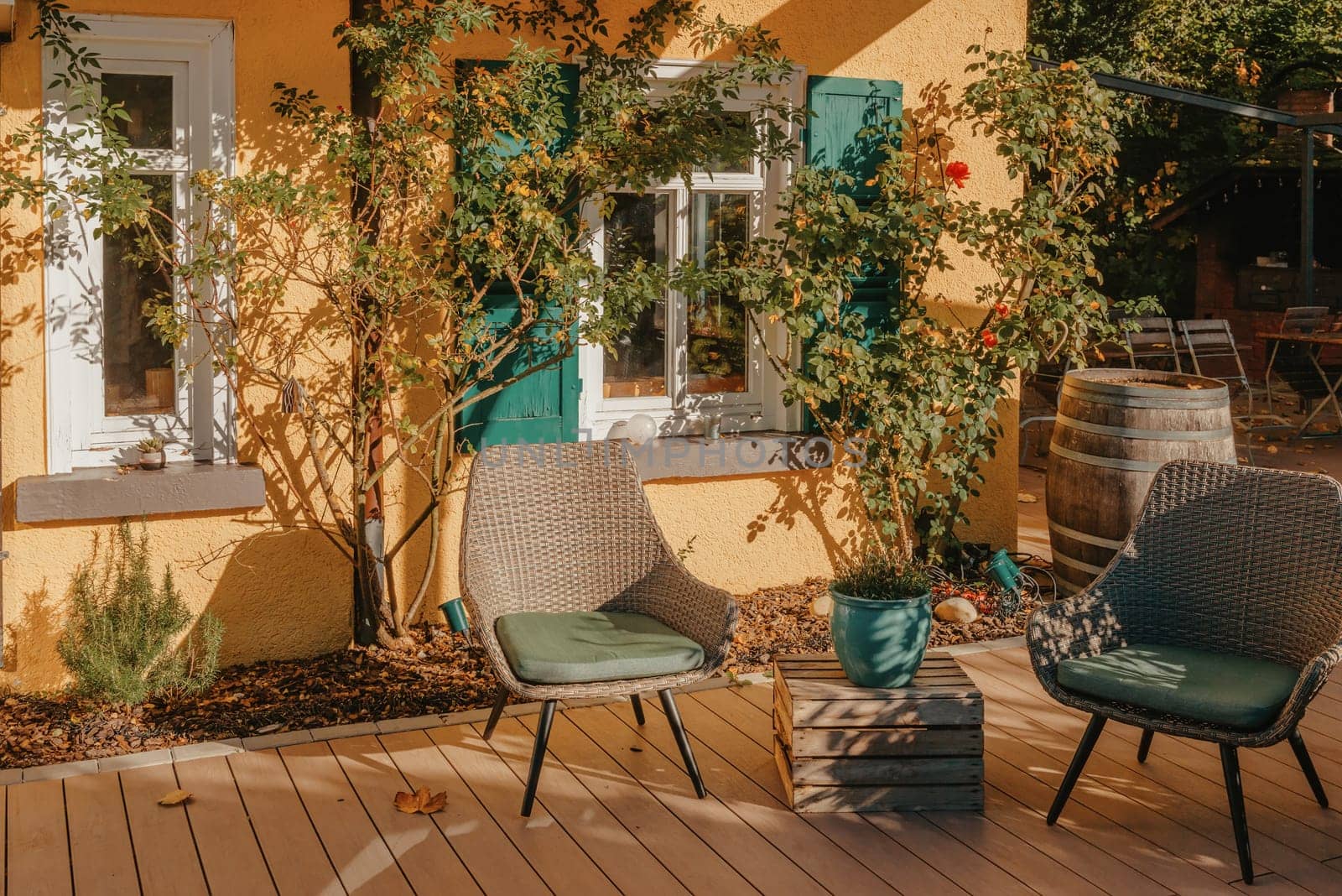 Image of a empty coffee tables arranged in backyard of a house. Autumn in Germany, Europe. Outdoor table in street cafe. autumn outdoor cafe wooden furniture old europe. Autumn photo of old-fashioned cozy and empty outdoor cafe with wooden furniture in a European town. Cafe concept by Andrii_Ko