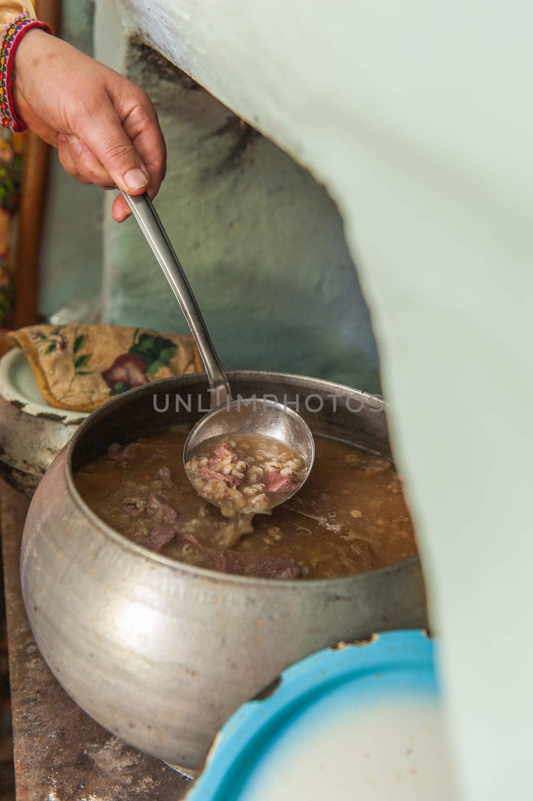 Traditional cooking in iron cast cauldron in wooden fire stove