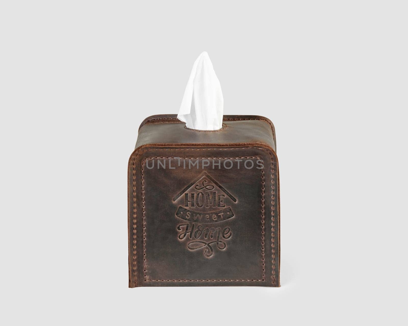 Stylish and convenient brown leather tissue box cover decorated with embossing, isolated on white background. Artisanal home decor accessory