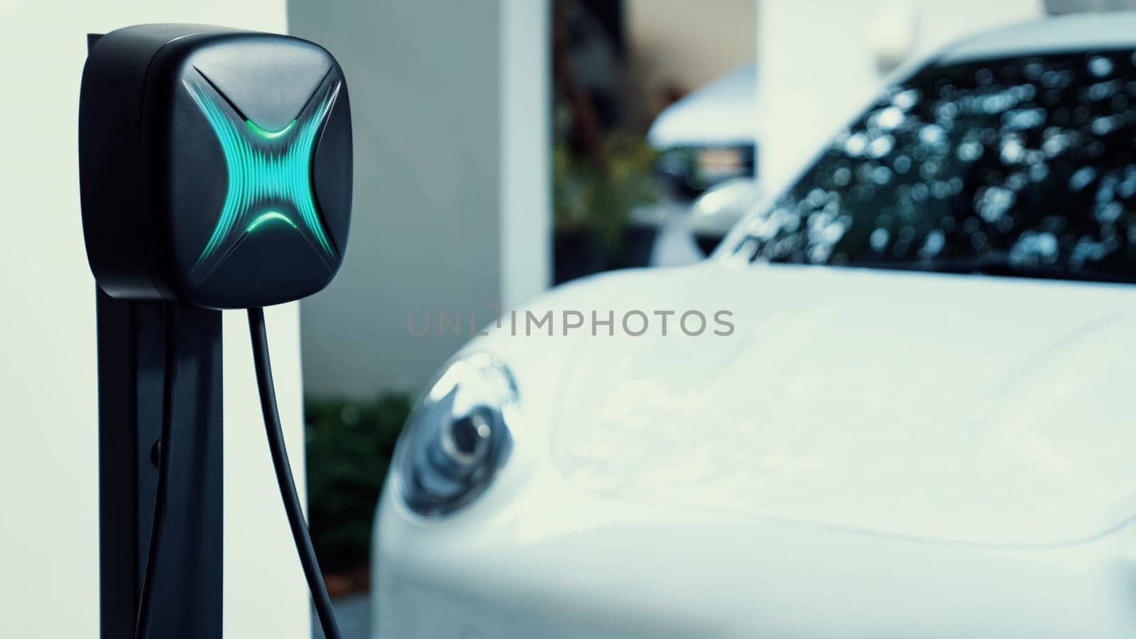 Electric car plugged in with home charging station. Peruse by biancoblue