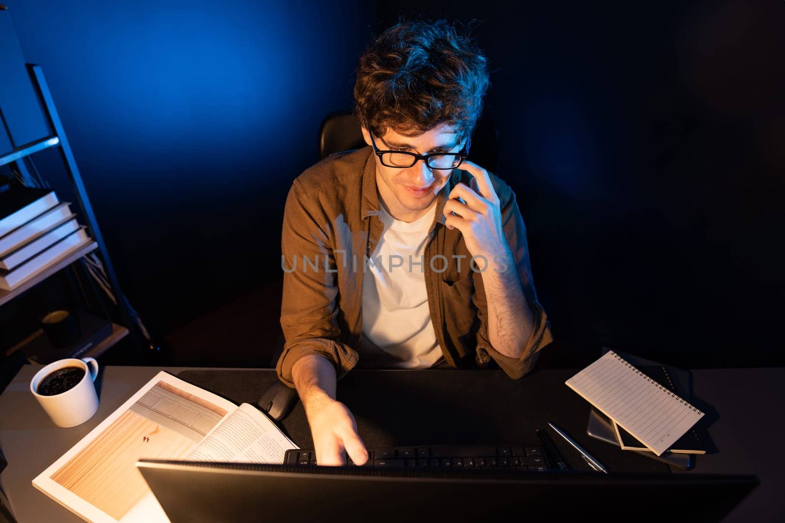 Young businessman concentrating on pc for creative startup project job at neon light modern office. Thinking marketing network online planning of creator to market channel design concept. Gusher.