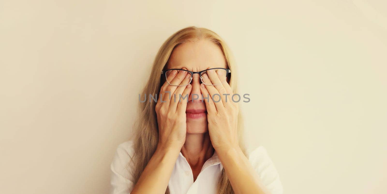 Tired overworked woman employee rubbing her eyes suffering from eye strain, dry eye syndrome or headaches