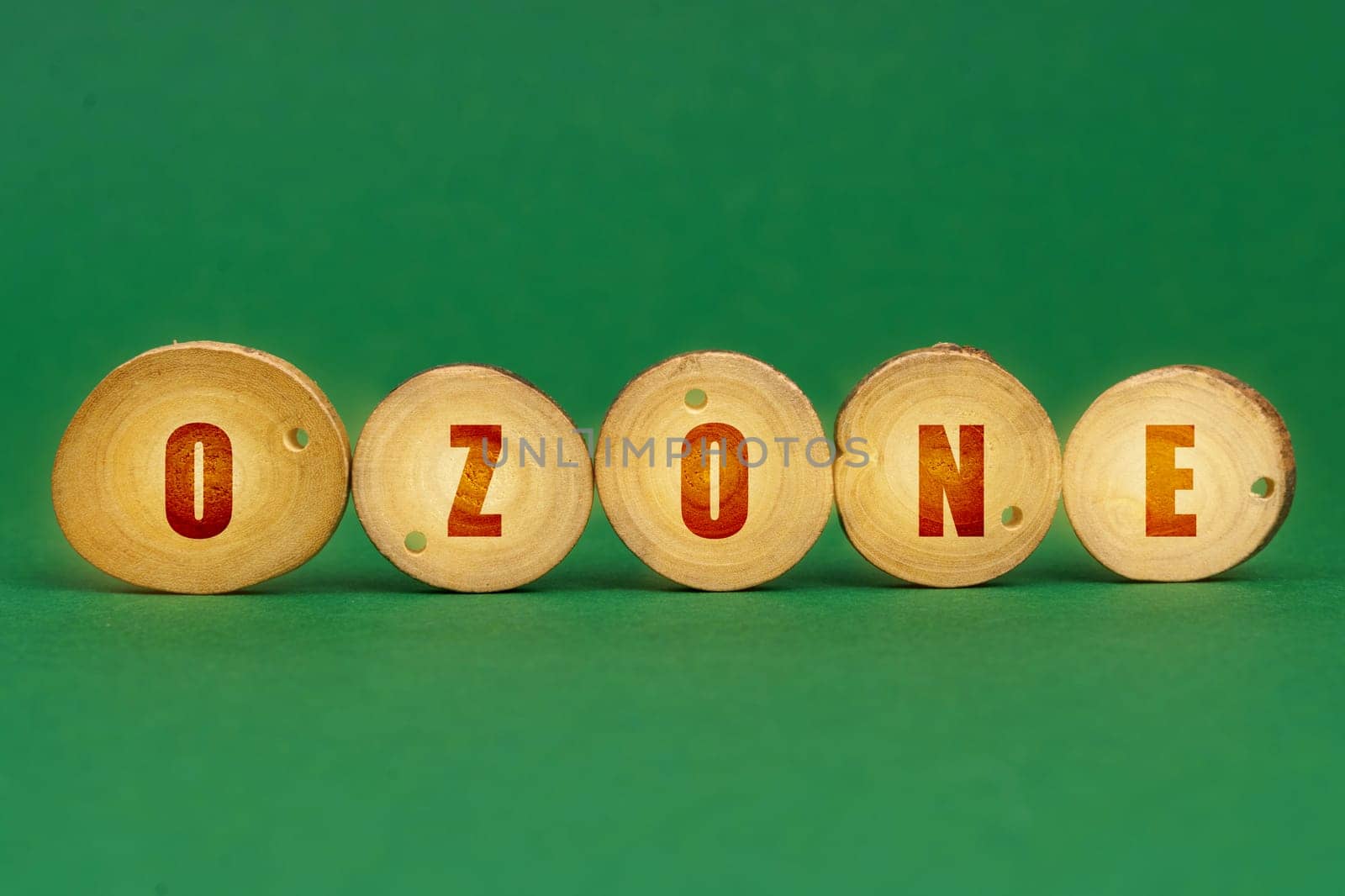 Ecological concept. On a green background, wooden roundels with the inscription - Ozone
