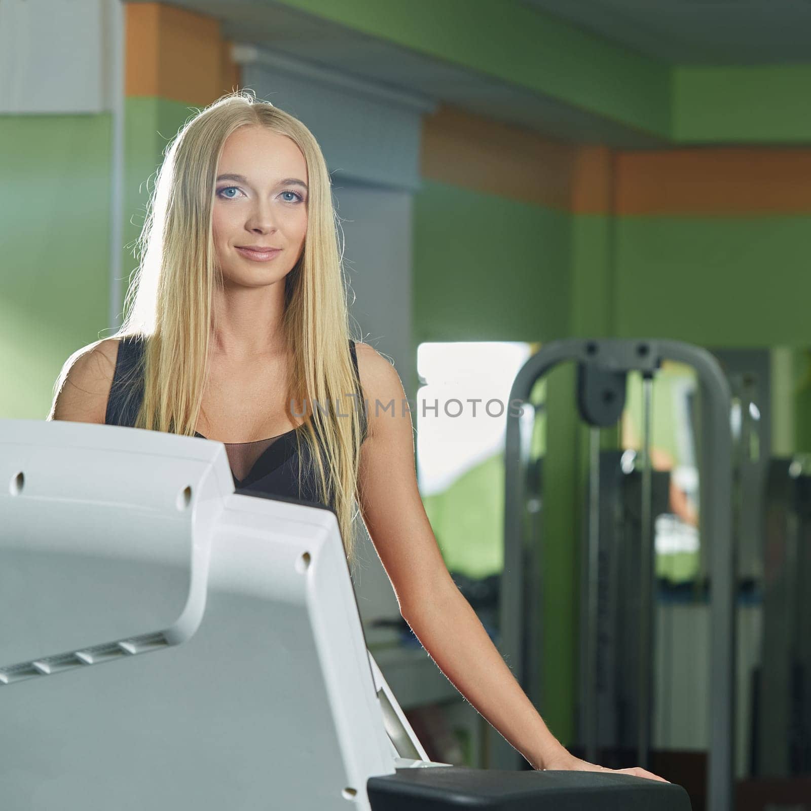 Gym. Image of attractive blonde exercising on treadmill