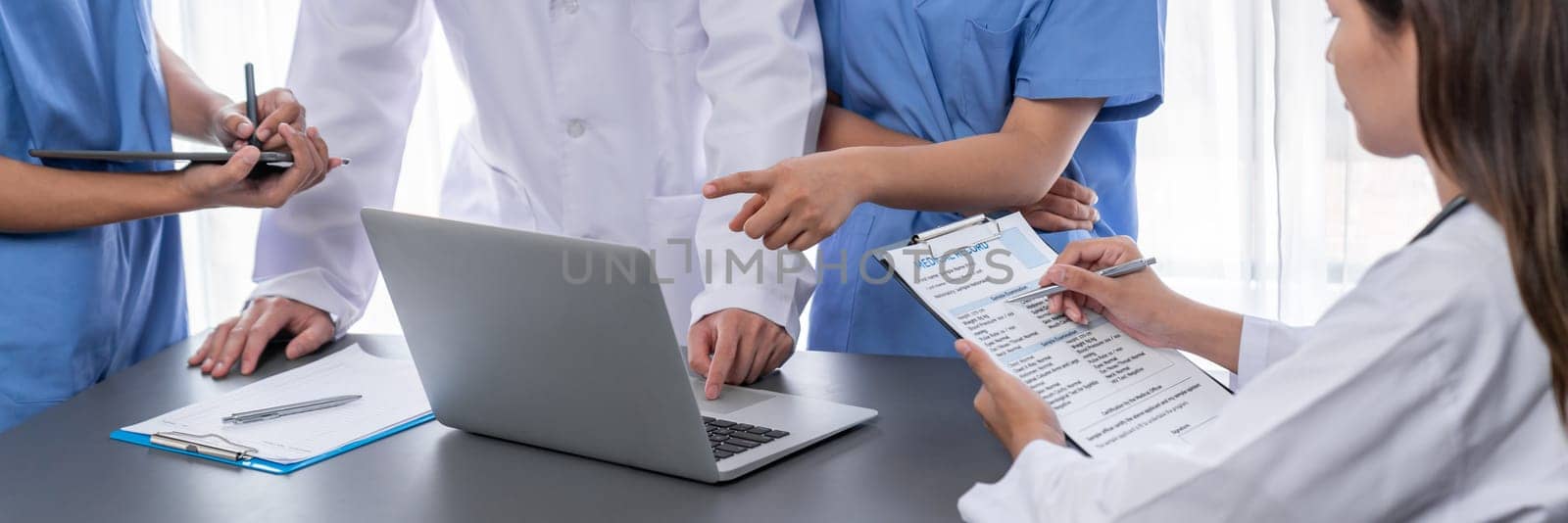 Doctor and nurse in medical meeting discussing strategic medical treatment plan together with report and laptop. Medical school workshop training concept in panoramic banner. Neoteric