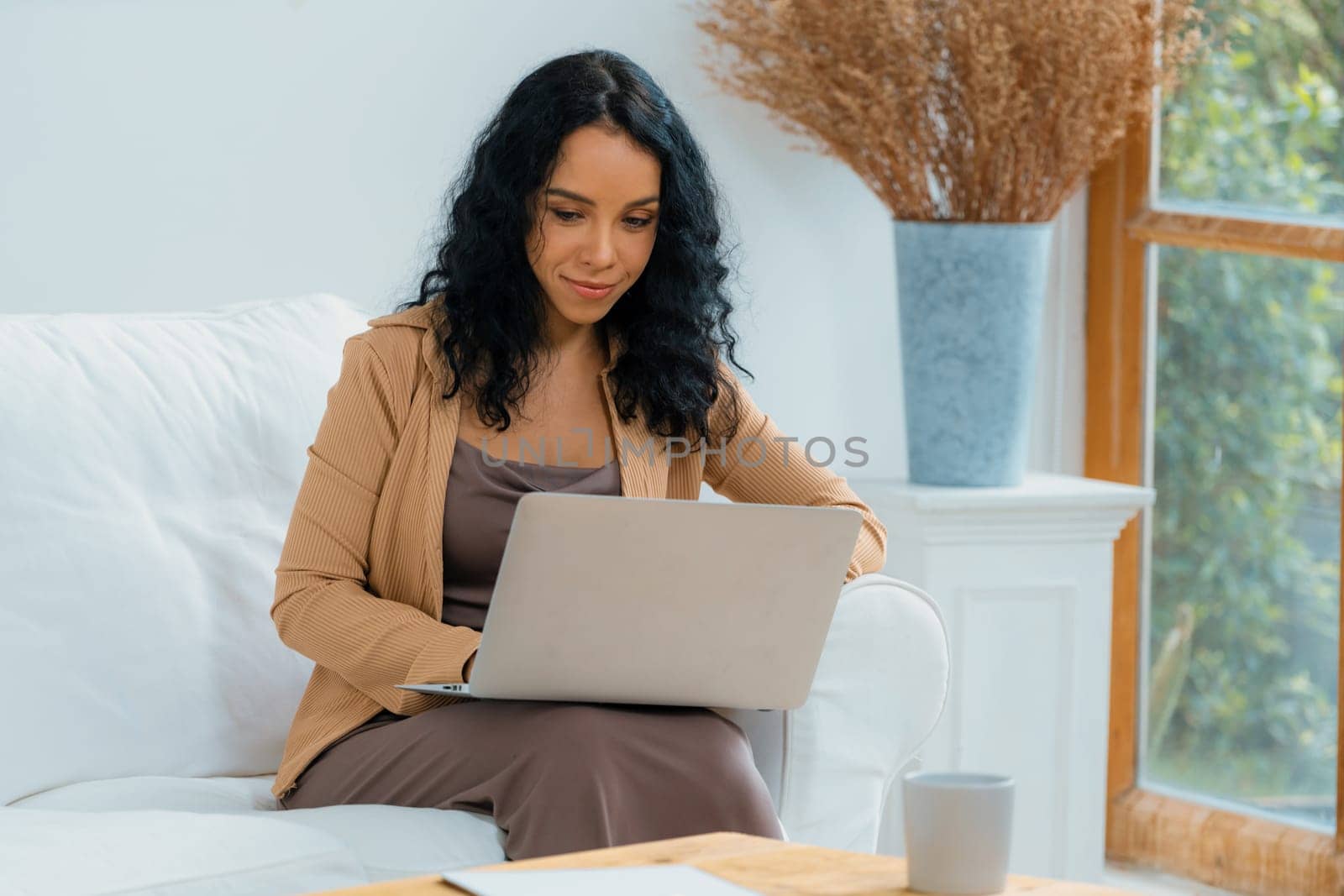 African-American woman using laptop computer for crucial work on internet. Secretary or online content writing working at home.