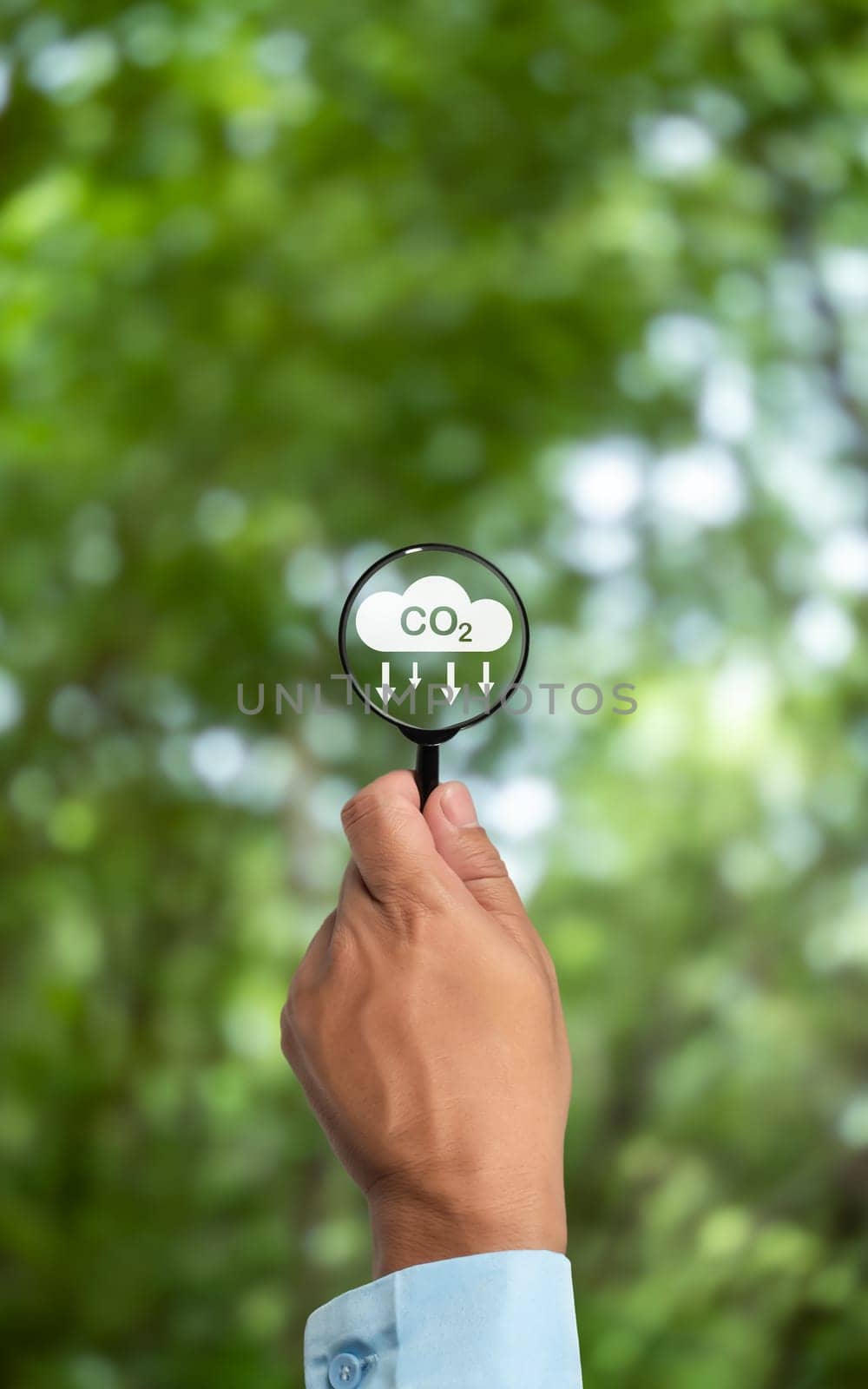 A clean and friendly environment without carbon dioxide emissions, Hand holding magnifying glass with CO2 reduction icon inside, carbon credit to limit global warming from climate change, carbon neutral. by Unimages2527