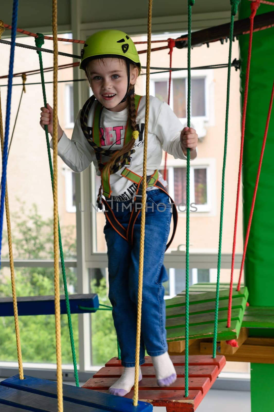 Children's cableway in the playroom, little girl passes the cableway. by Niko_Cingaryuk