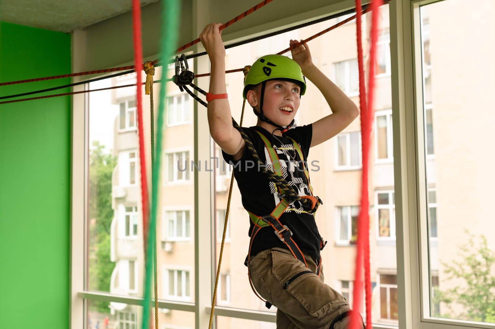 Ropeway is one of the types of physical development for children, a boy passes the ropeway in the playroom.