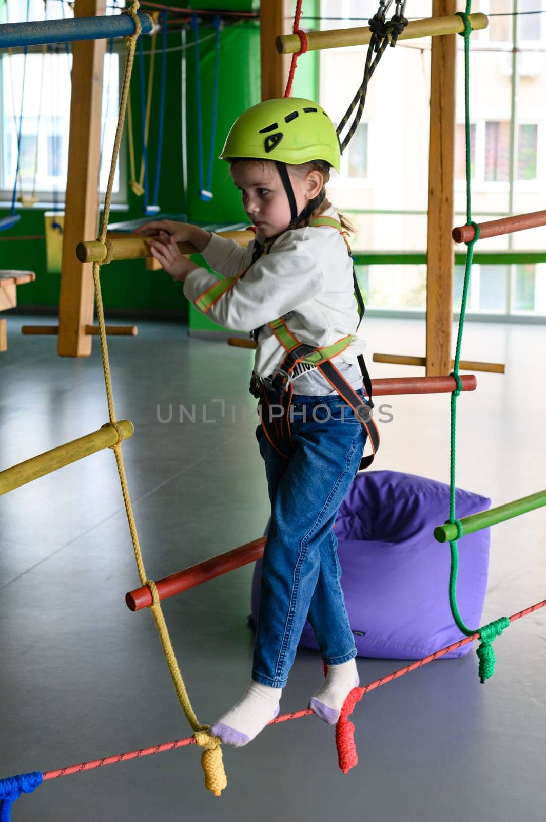 active and physical development of the child, the girl passes the cableway in the playroom.