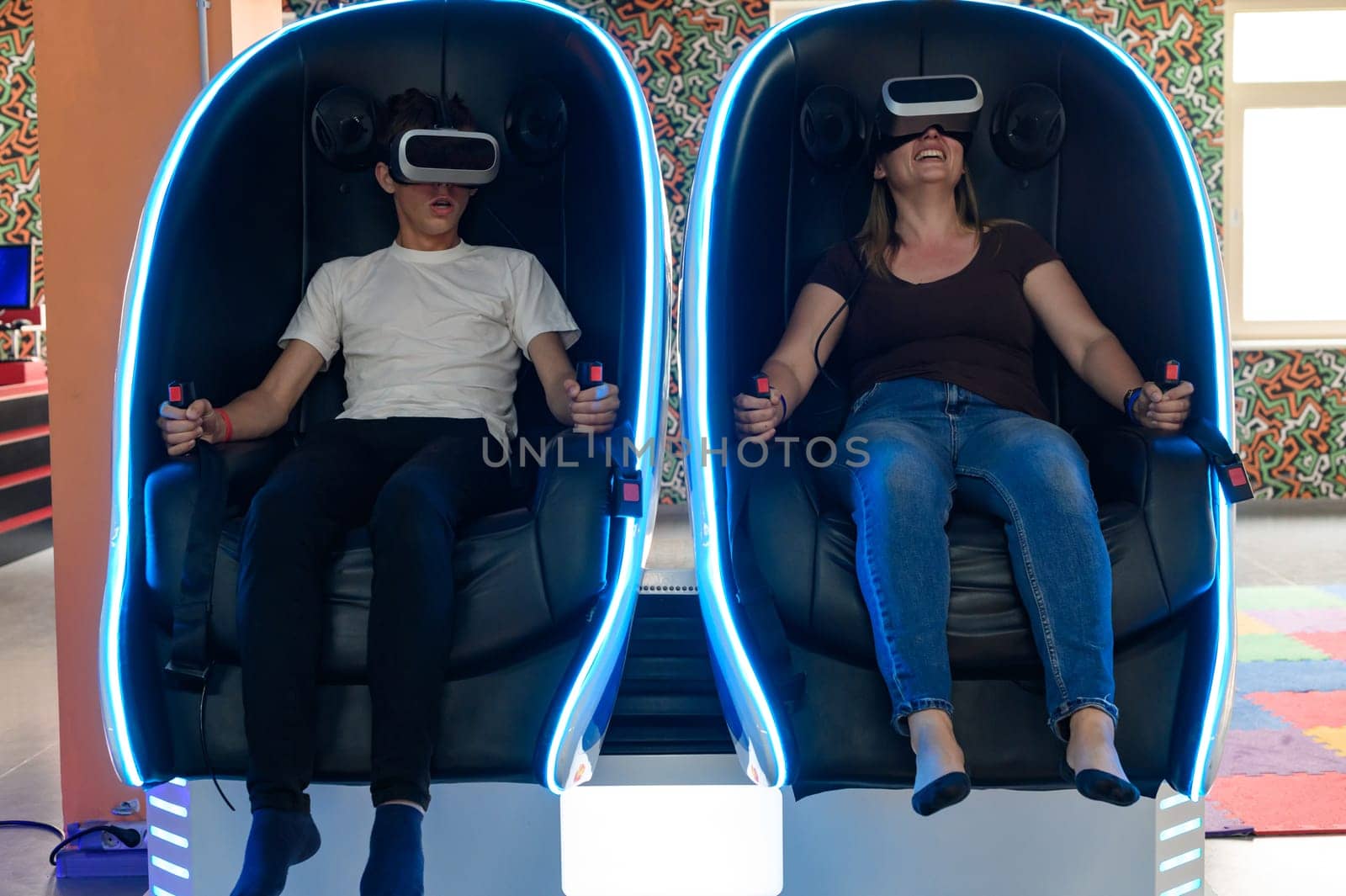 Virtual reality attraction, son and mother experience adrenaline from virtual reality, 5D sensation.