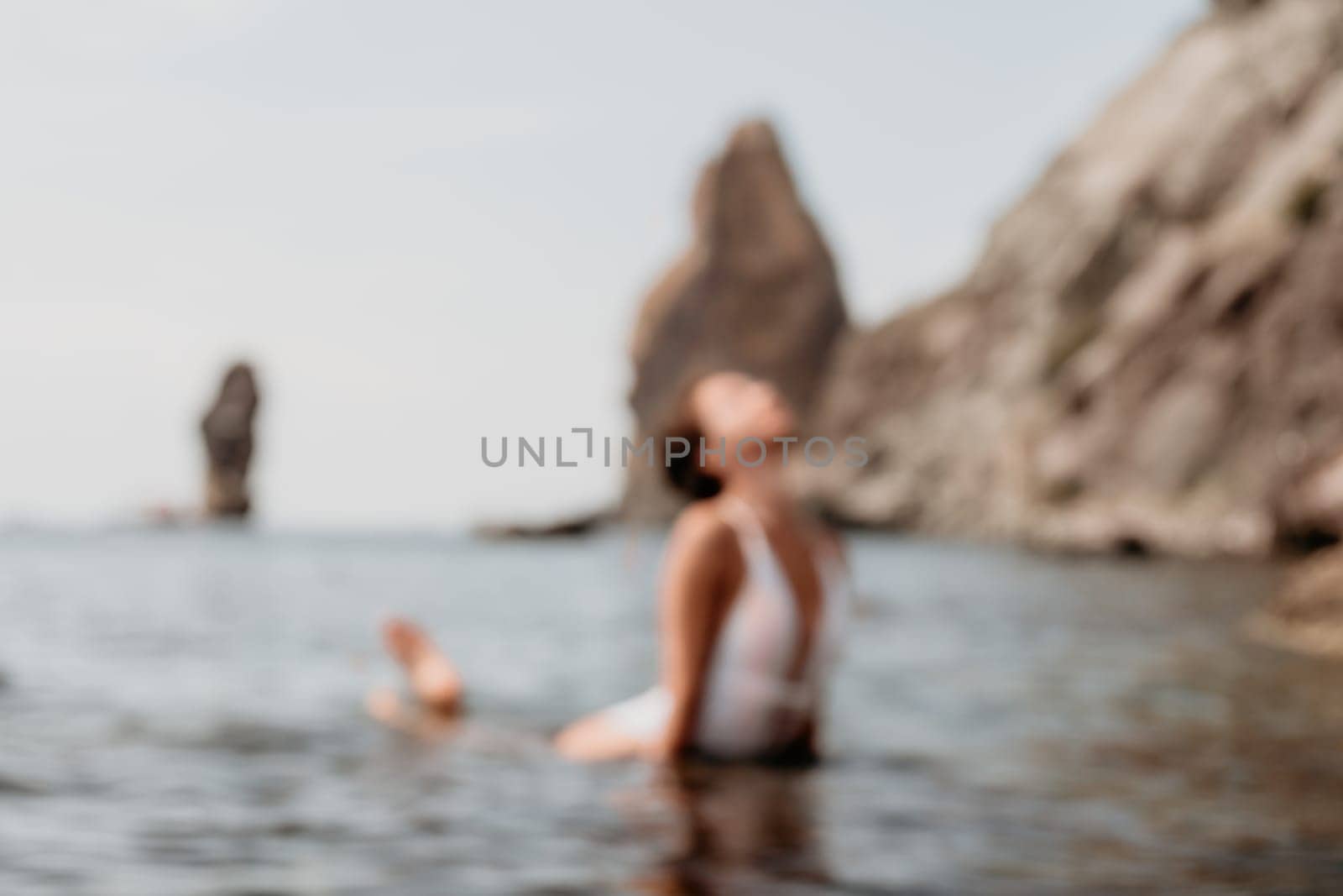 Abstract blur defocused woman sea fitness. Happy woman in a white bikini performing pilates in the sea on the beach. Female fitness yoga routine concept. Healthy lifestyle. by panophotograph