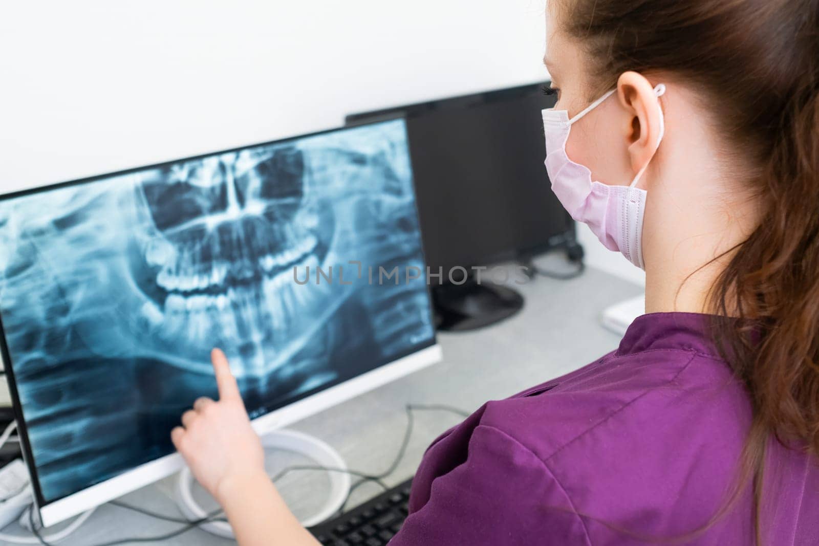 Dentist checks the X ray of the teeth in dentist office.