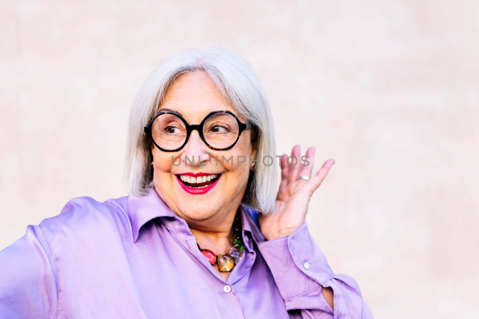 portrait of friendly smiling senior woman touching her hair, concept of happiness of elderly people and active lifestyle, copy space for text