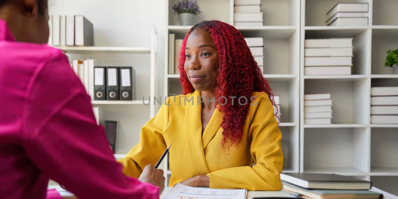 Two businesswoman African American working together using laptop and talking about a business project. team of females executive meeting work in office by nateemee