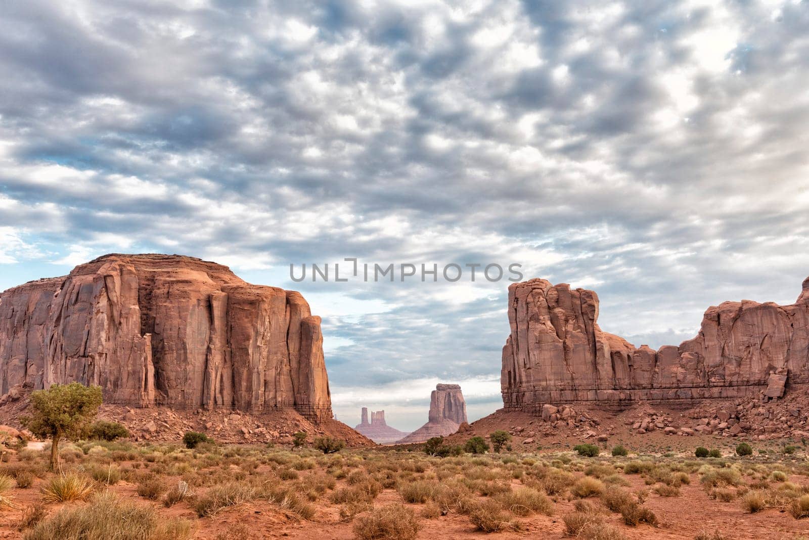 Monument Valley view at sunset with wonderful cloudy sky and lights on mittens