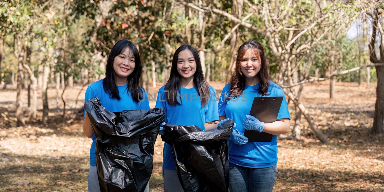 Volunteer collecting plastic trash in the forest. The concept of environmental conservation. Global environmental pollution. Cleaning the forest by nateemee