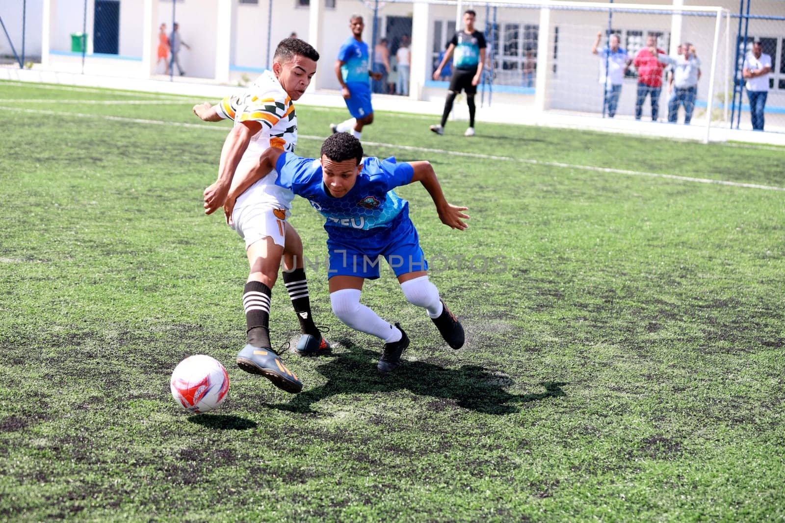 salvador, bahia, brazil - december 10, 2023: young people are seen playing football on a field with synthetic grass in the city of Salvador.