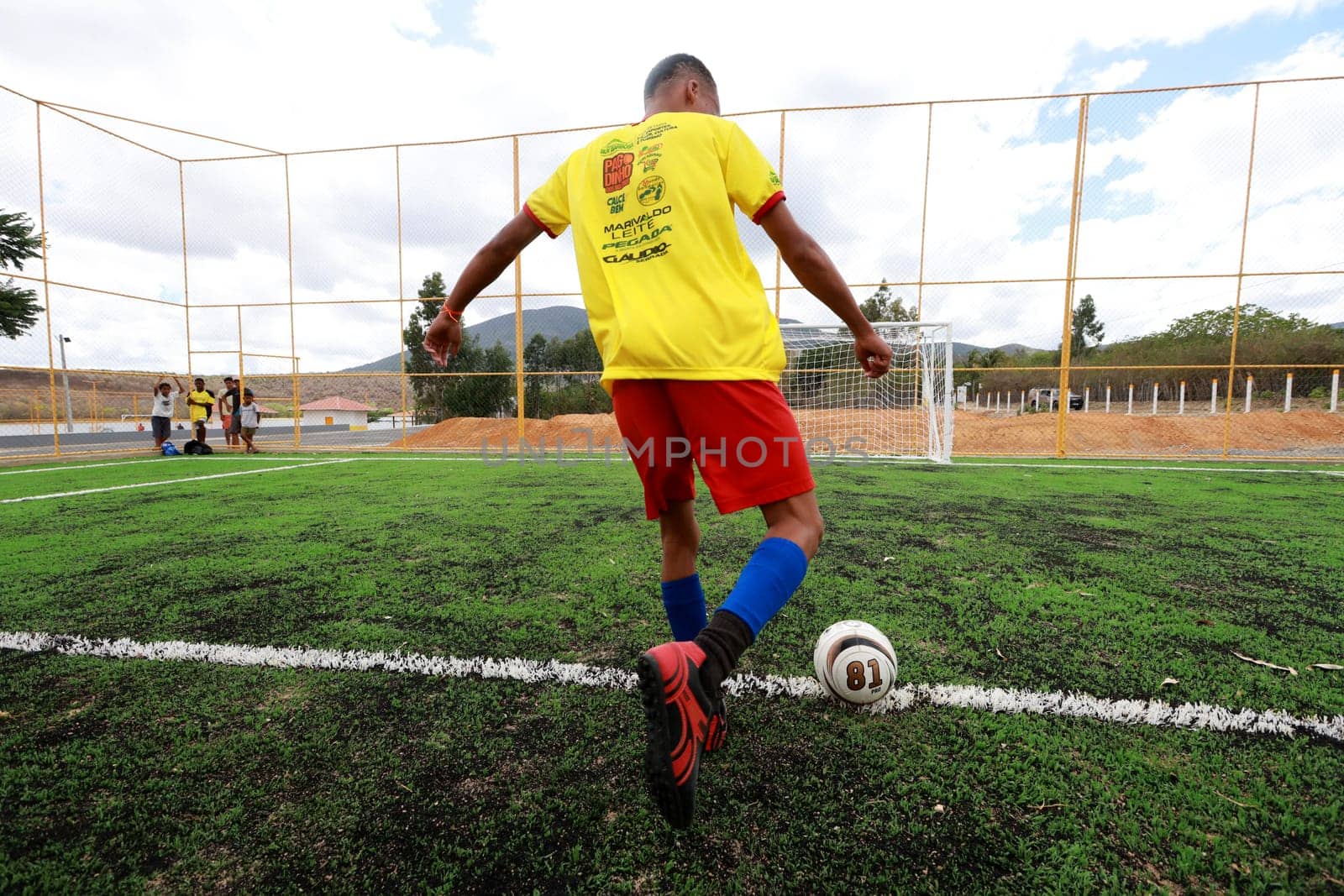 salvador, bahia, brazil - december 10, 2023: young people are seen playing football on a field with synthetic grass in the city of Salvador.