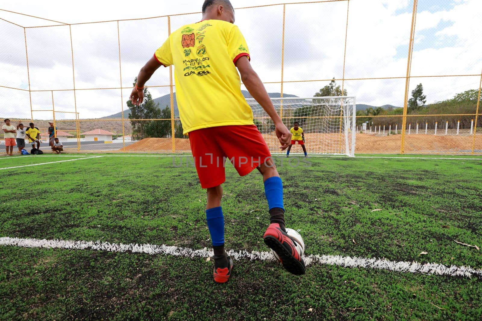 salvador, bahia, brazil - december 10, 2023: young people are seen playing football on a field with synthetic grass in the city of Salvador.