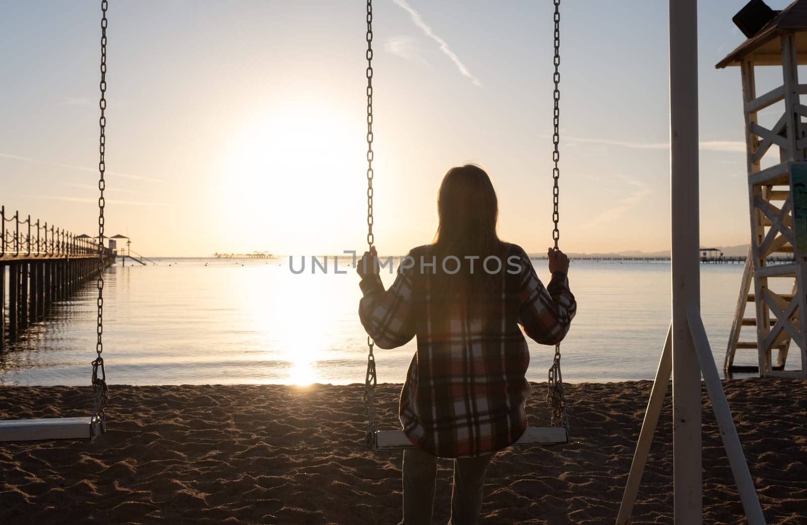 beautiful young woman on the swing on the sky background by Desperada