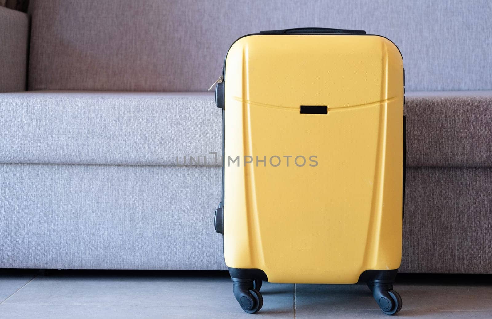 yellow suitcase on sofa background in hotel room by Desperada