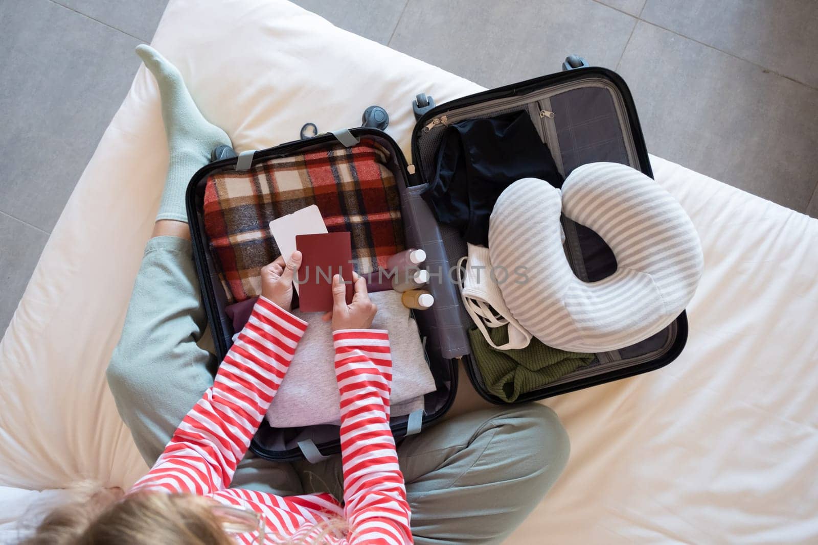happy woman preparing for holidays, packing suitcase on bed