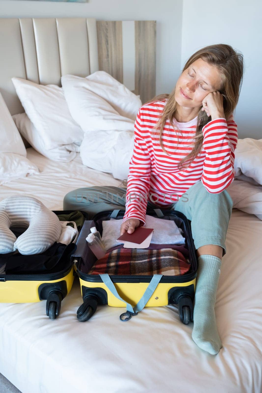 happy woman preparing for holidays, packing suitcase on bed