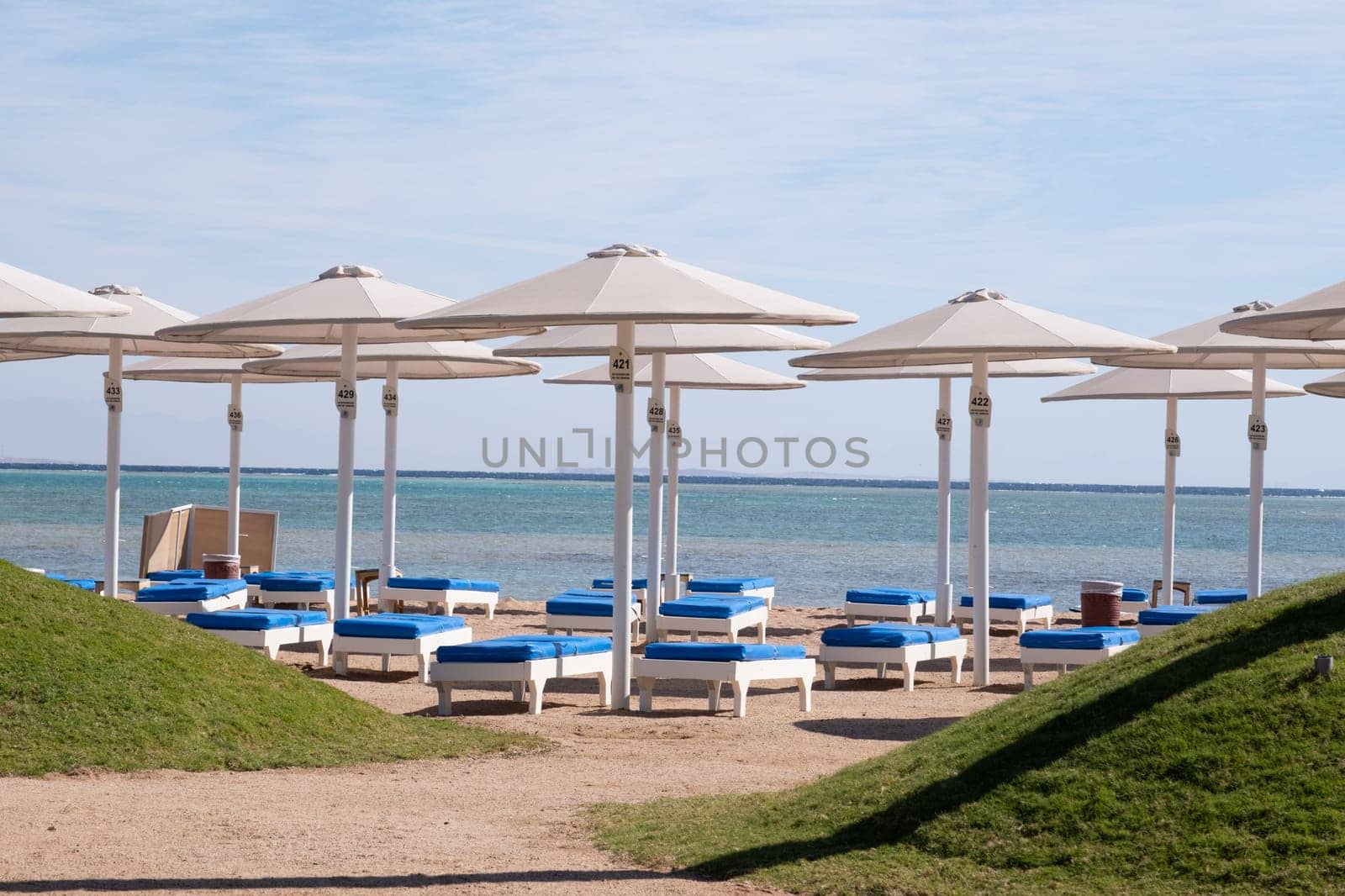 Empty beach with umbrellas and sun loungers by Desperada