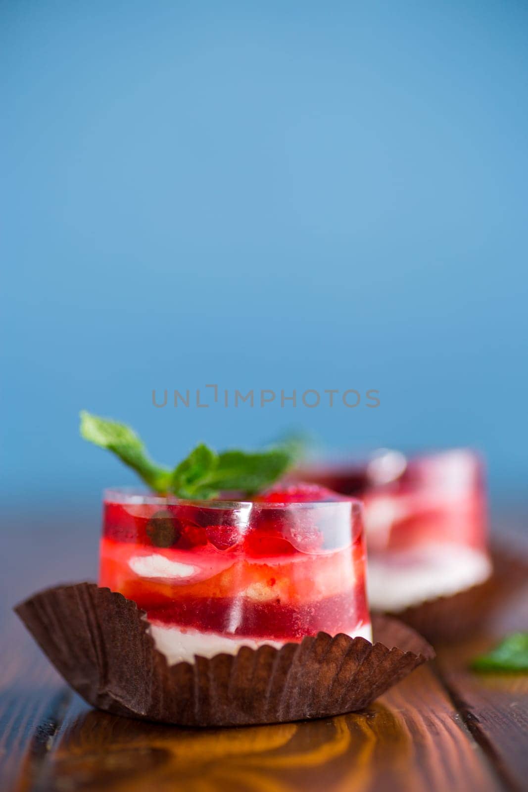 fruit cake with jelly, filled with berries, on a blue background.