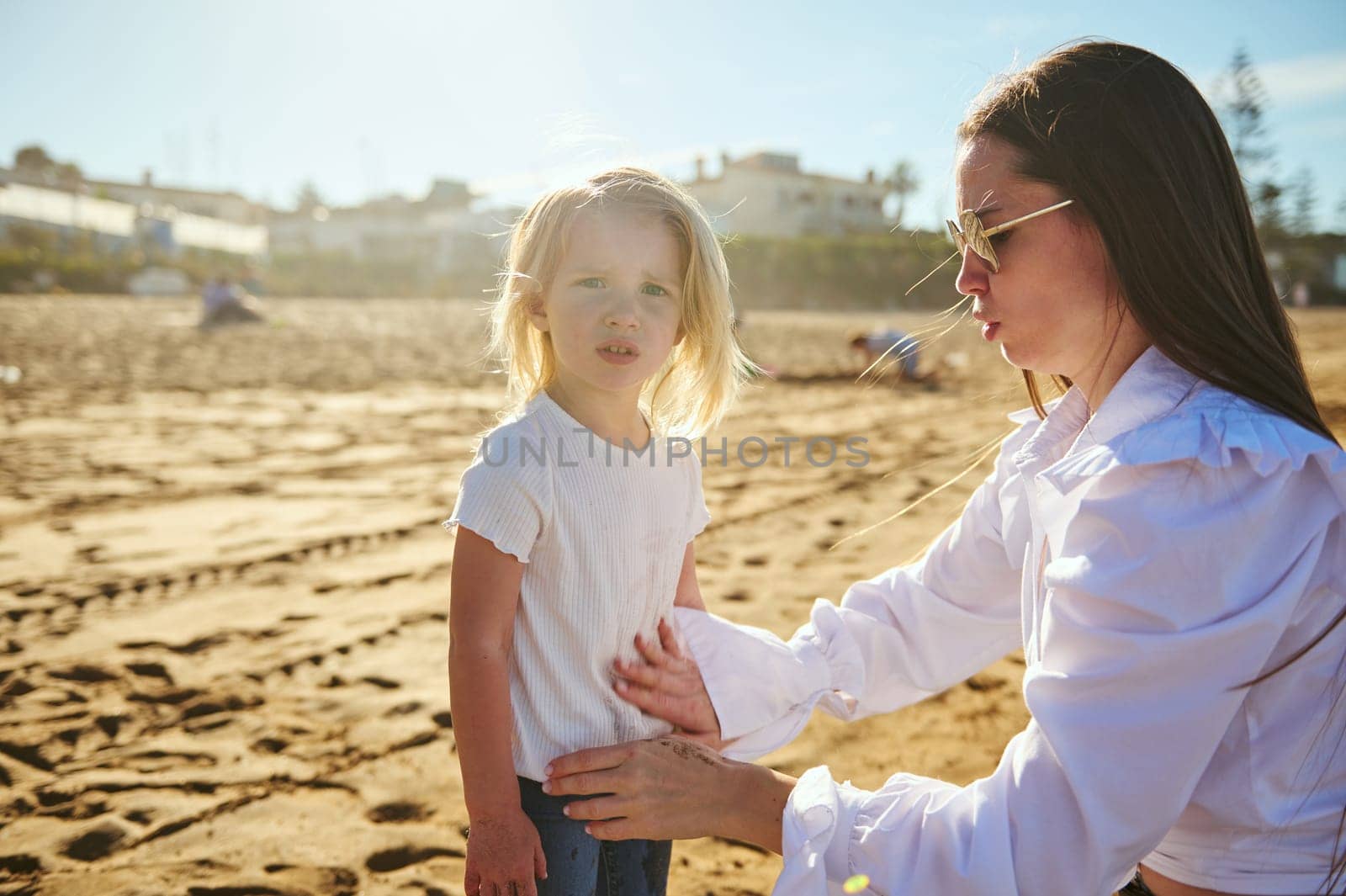Mom and daughter playing together on the sandy each on a sunny day by artgf