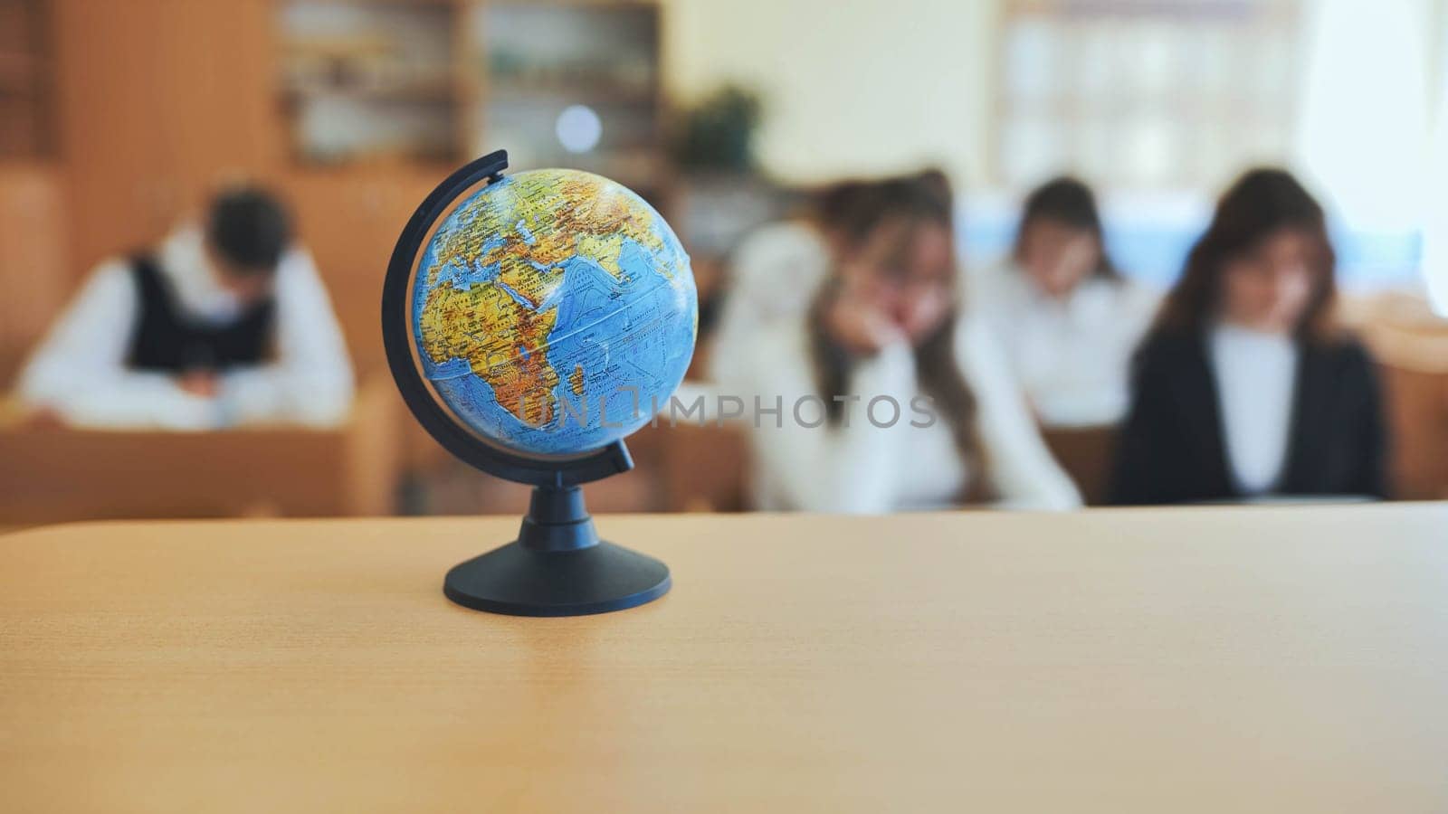 A globe of the world with textbooks in the background of a lesson in a school classroom. by DovidPro