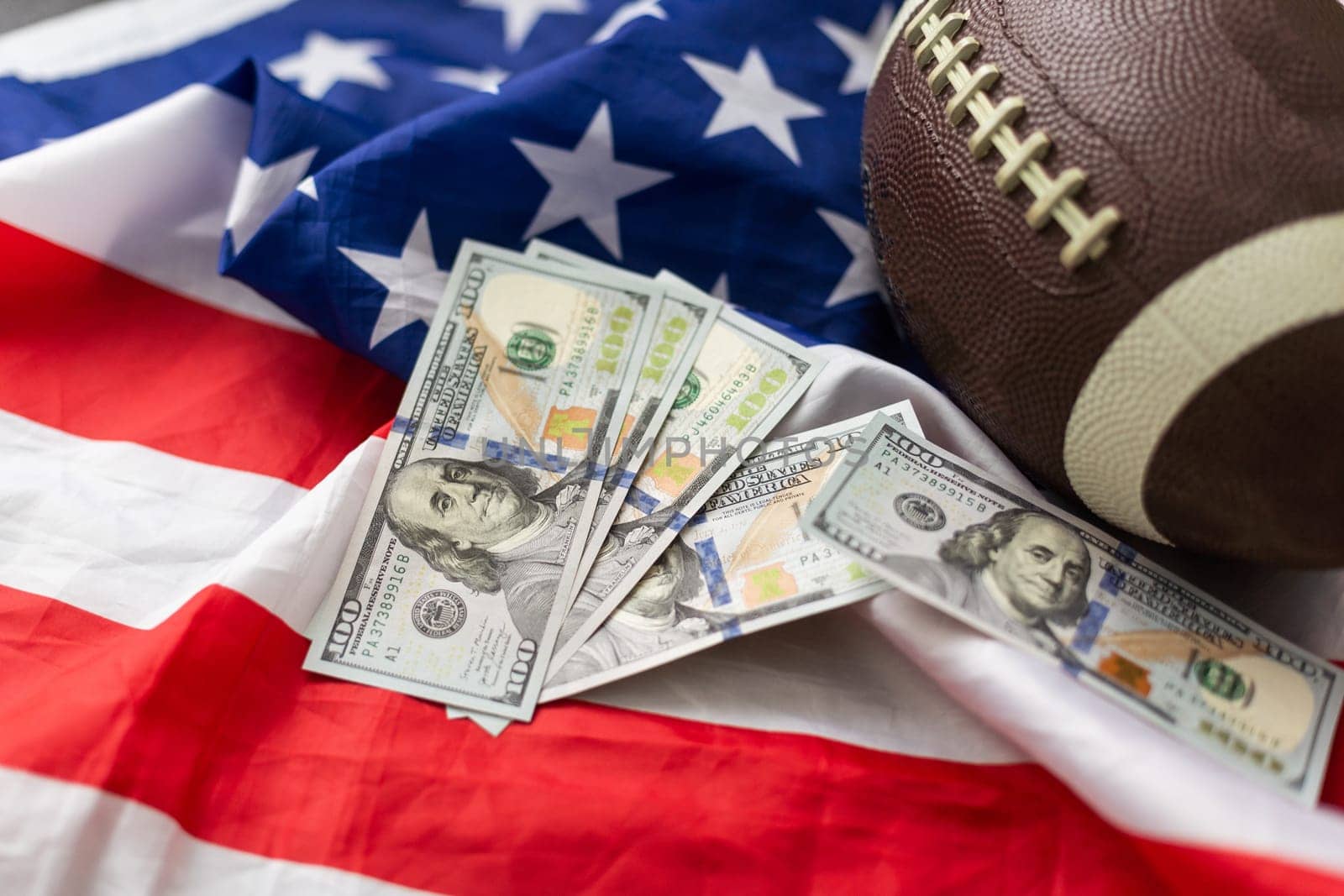 Money and rugby ball on american flag background, closeup. Concept of sports bet by Andelov13