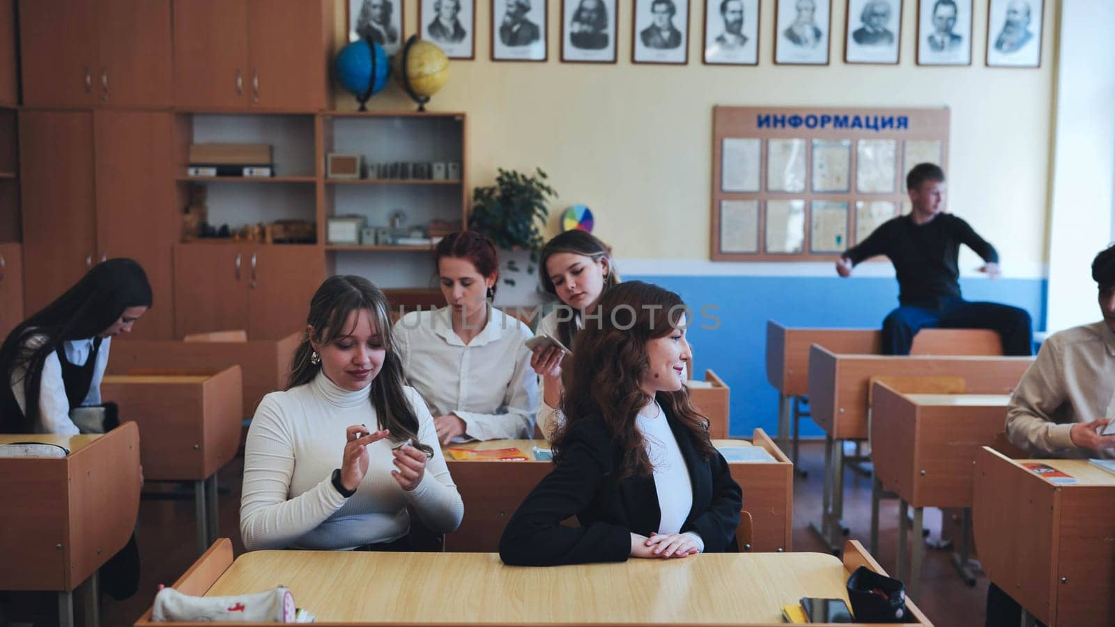 Berezovka, Belarus - May 15, 2023: High school seniors having fun in their classroom. by DovidPro
