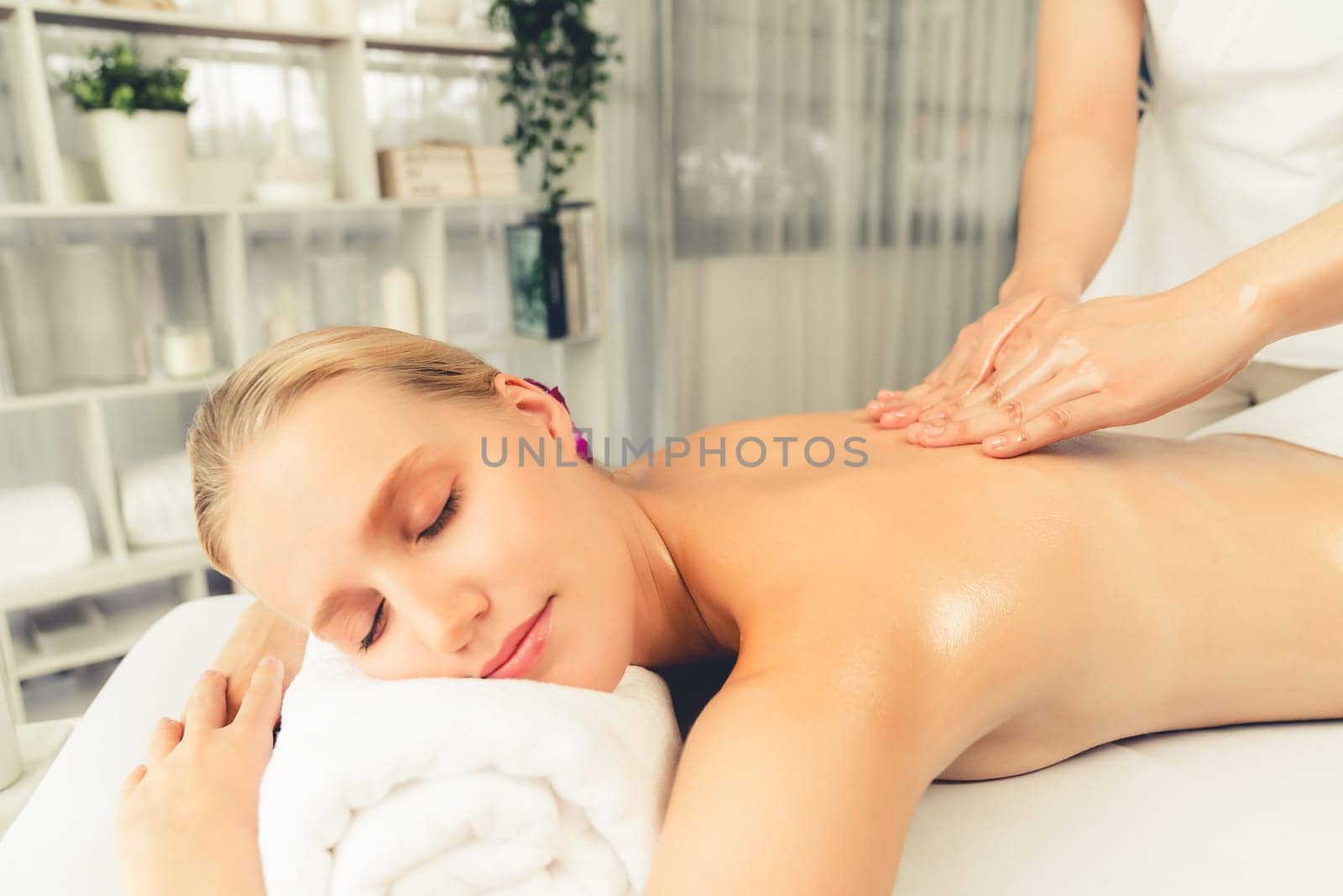 Caucasian woman customer enjoying relaxing anti-stress massage. Quiescent by biancoblue