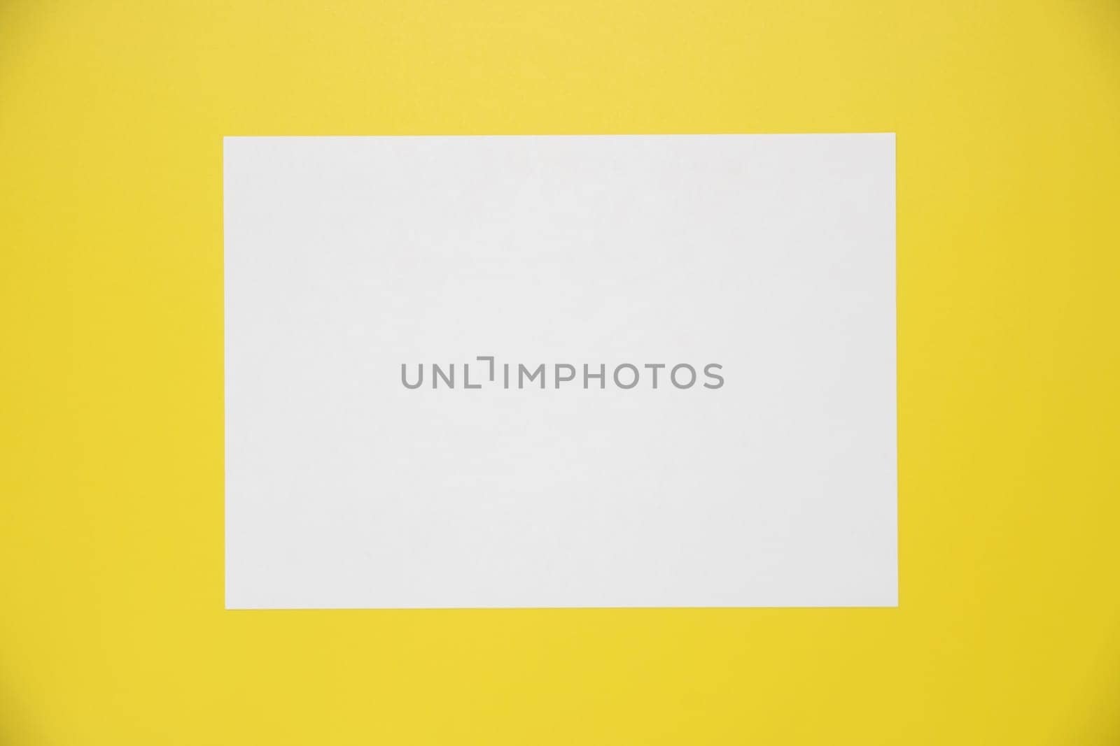 Empty white paper sheet isolated on yellow background.
