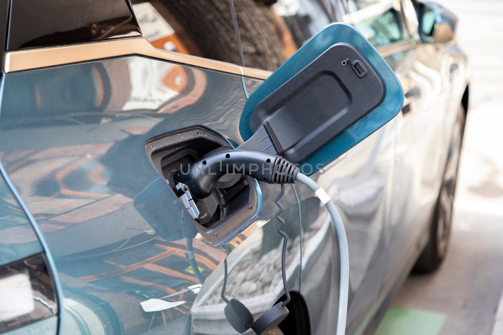 Close up of power supply plugged into an electric car being charged for hybrid 