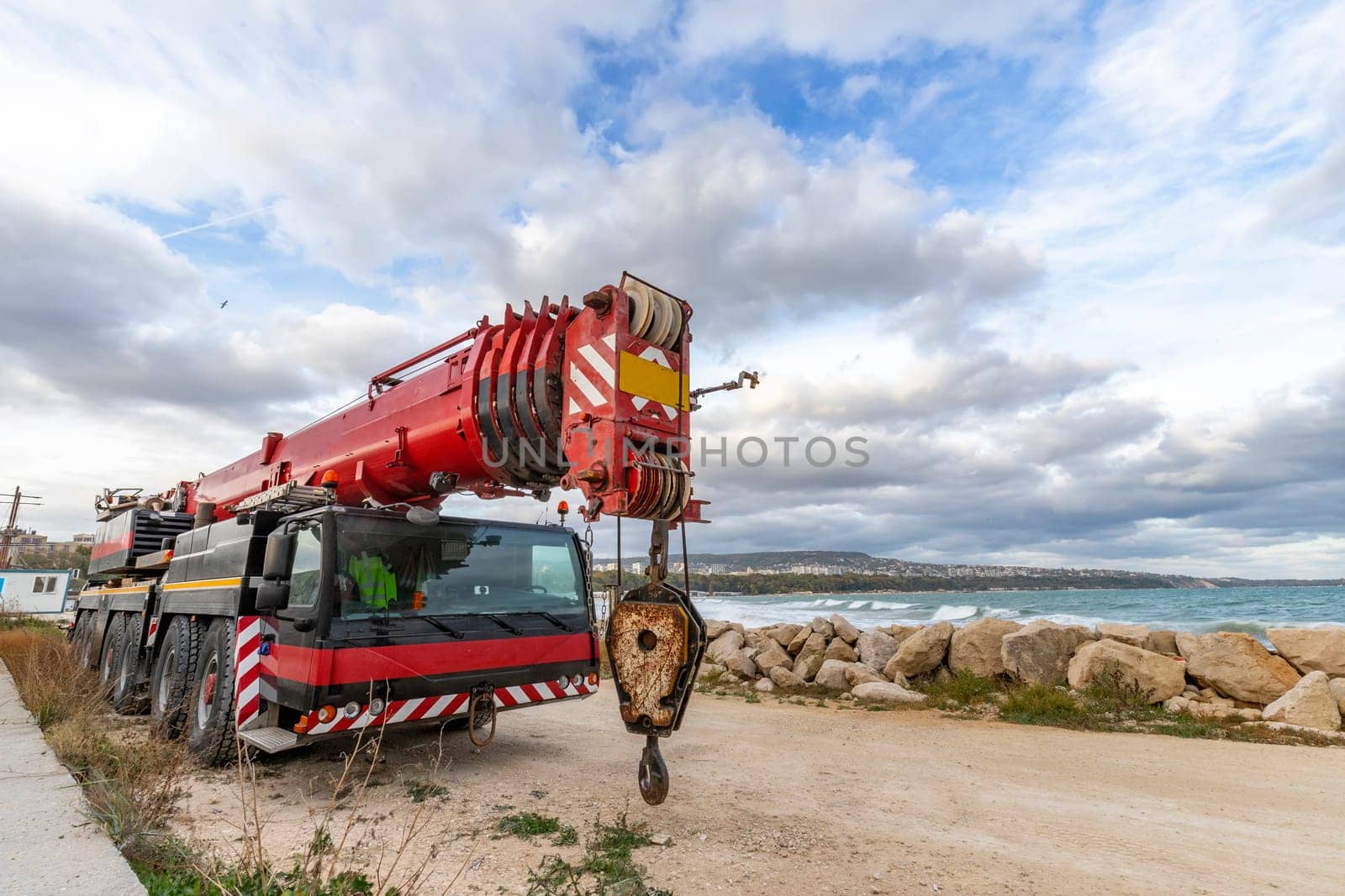 Heavy duty mobile crane parked near the sea. Telescopic truck mounted crane by EdVal