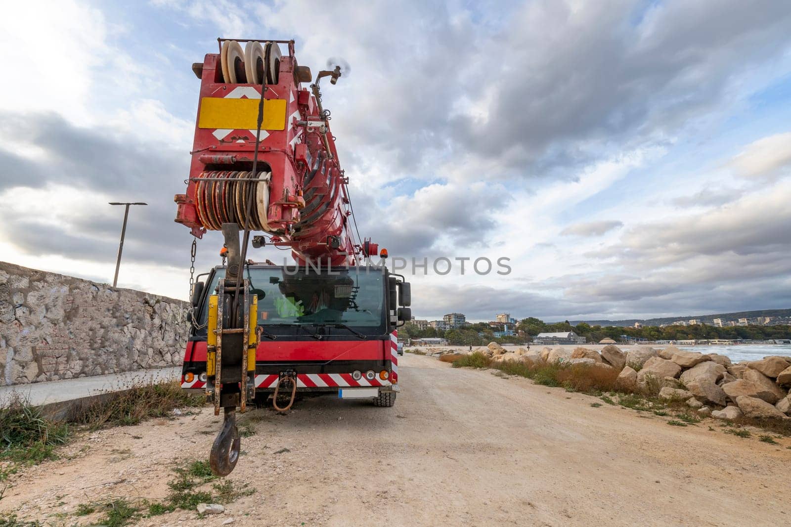 Heavy duty mobile crane parked near the sea. Telescopic truck mounted crane by EdVal