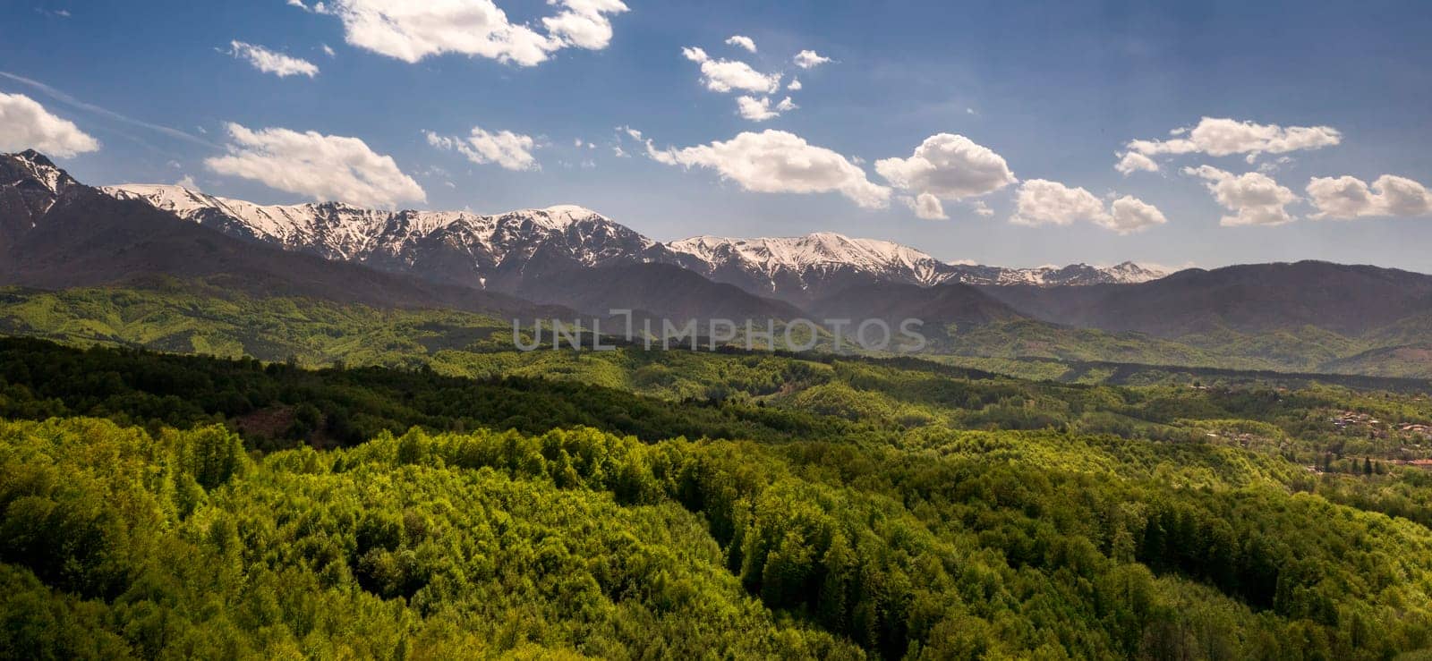 Stunning panoramic view from a drone of the mountain with snow peaks and green hills. by EdVal