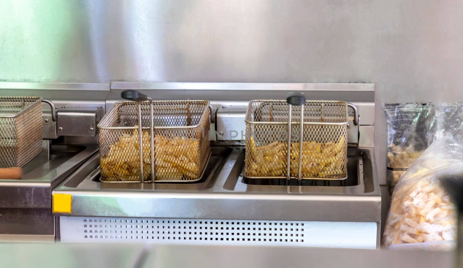 Ready potatoes for frying at the potato fryer. Fast food restaurant concept, kitchen equipment