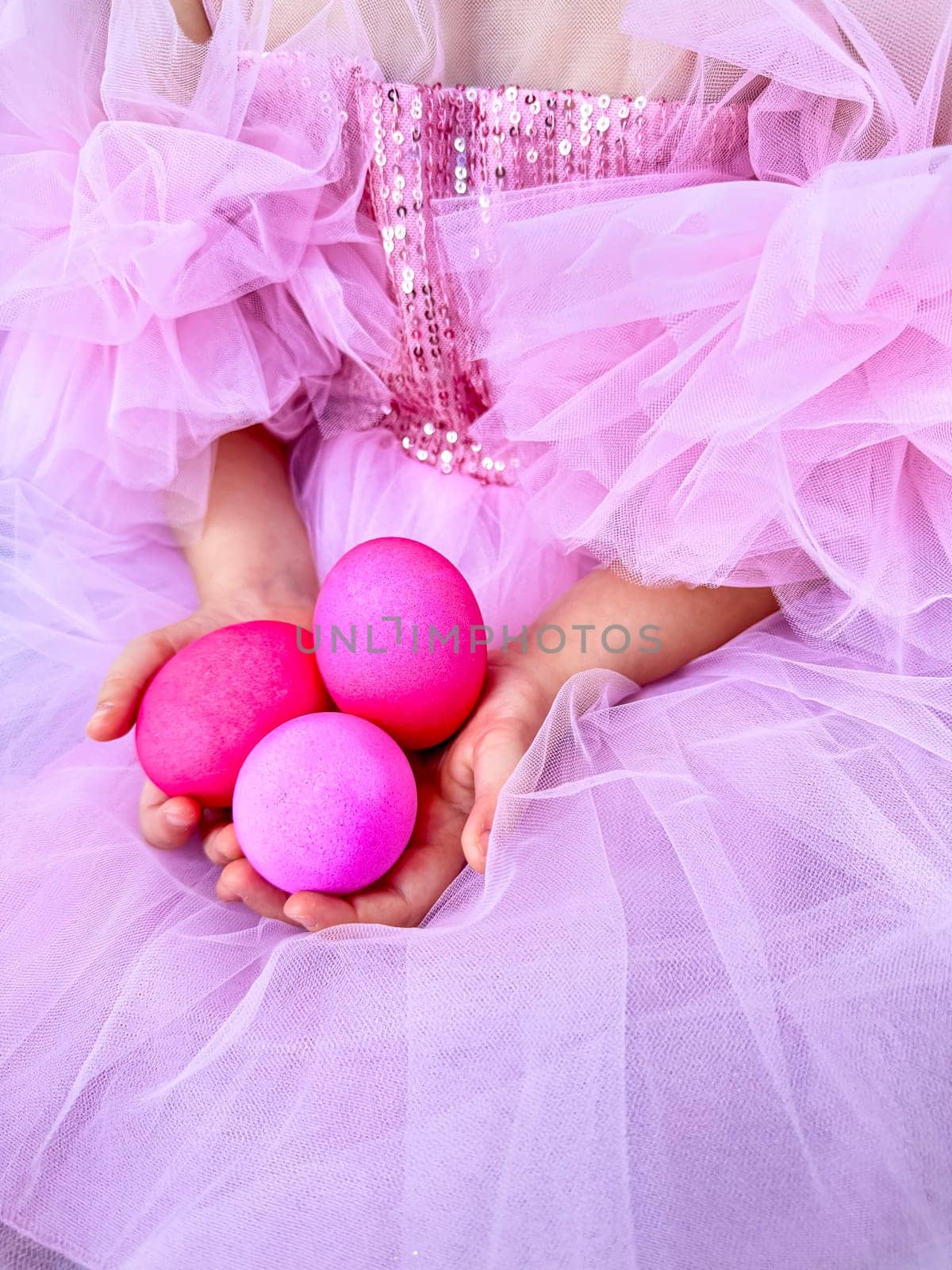 Child in pink tulle dress holding bright pink eggs, Easter celebration concept with a playful and festive feel. For Easter related marketing materials, event invitations, childrens party advertisements. High quality photo