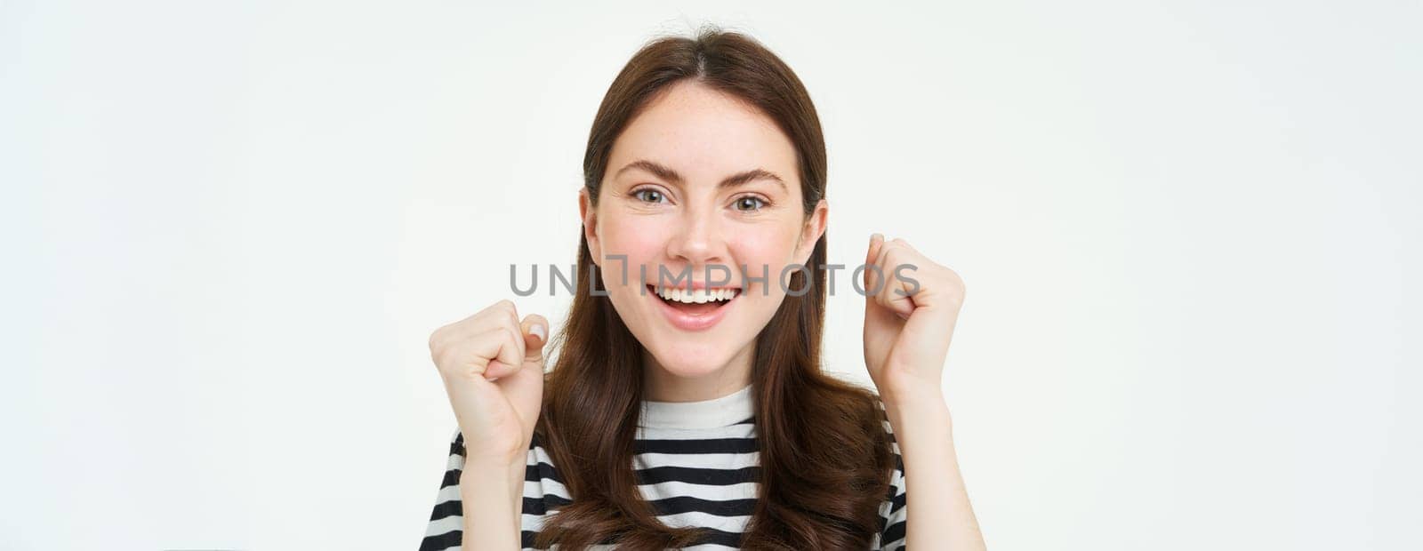 Close up portrait of cheerful woman, raising hands up and smiling, celebrating success, achievement or goal, rooting for you, looking excited at camera, white background by Benzoix