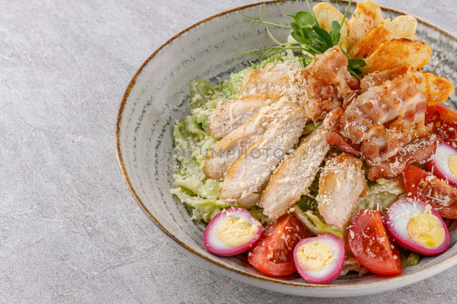 Caesar salad with chicken and bacon on a stone background studio food photo 5