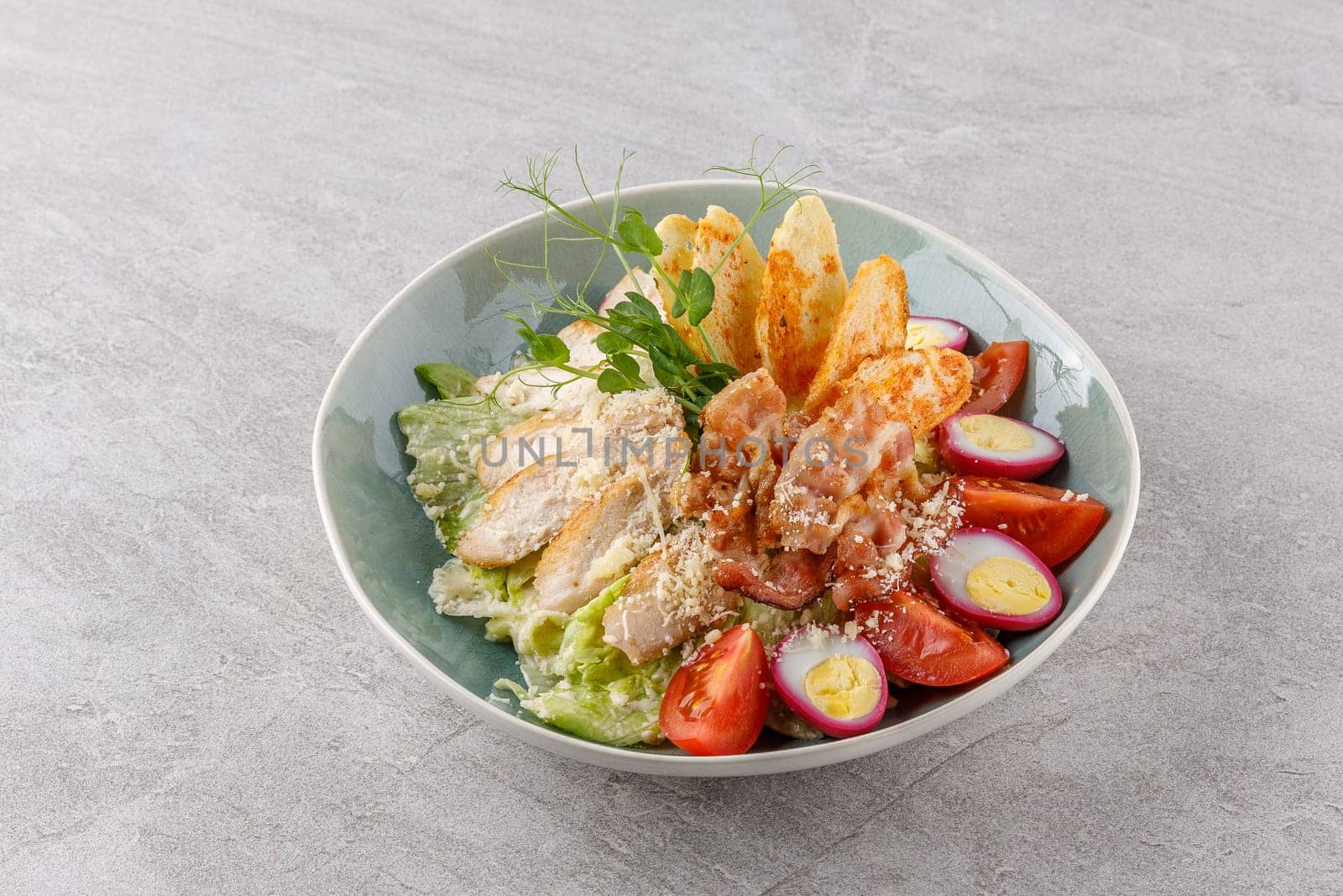 Caesar salad with chicken and bacon on a stone background studio food photo 4