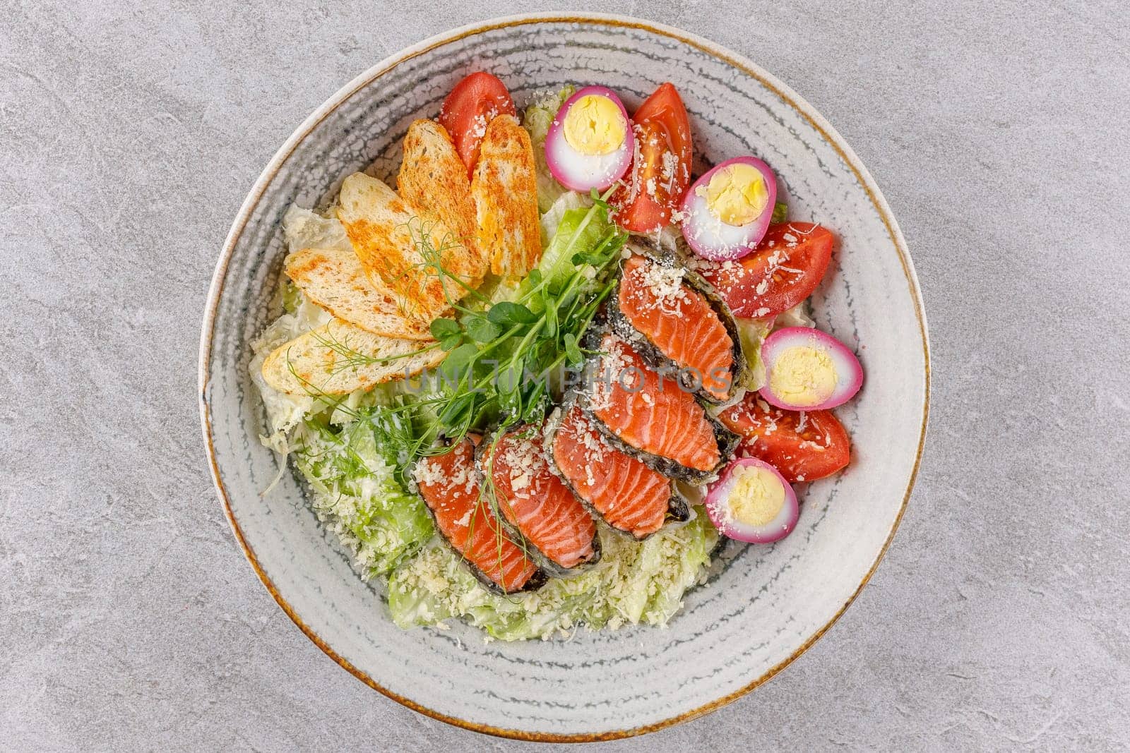 Caesar salad with baked salmon on a stone background studio food photo 2