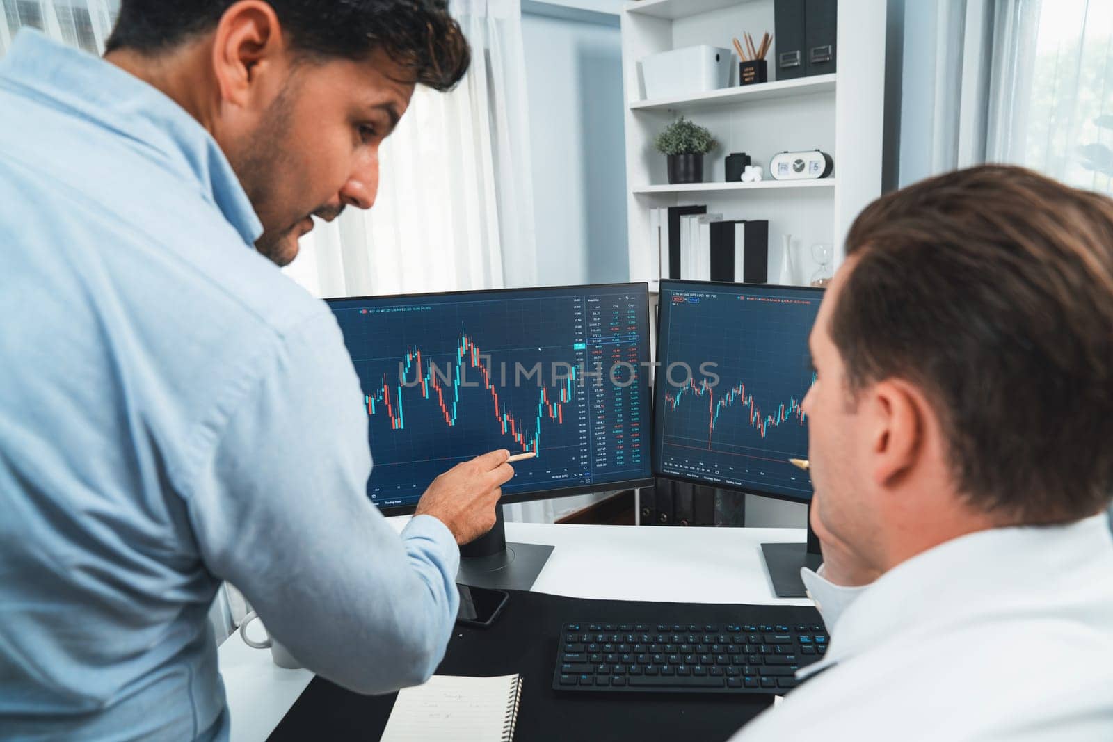 Stock exchange traders discussing digital currency or market online focusing on real time dynamic data with two screen, analyzing increased possible trend investment at modern workplace. Sellable.